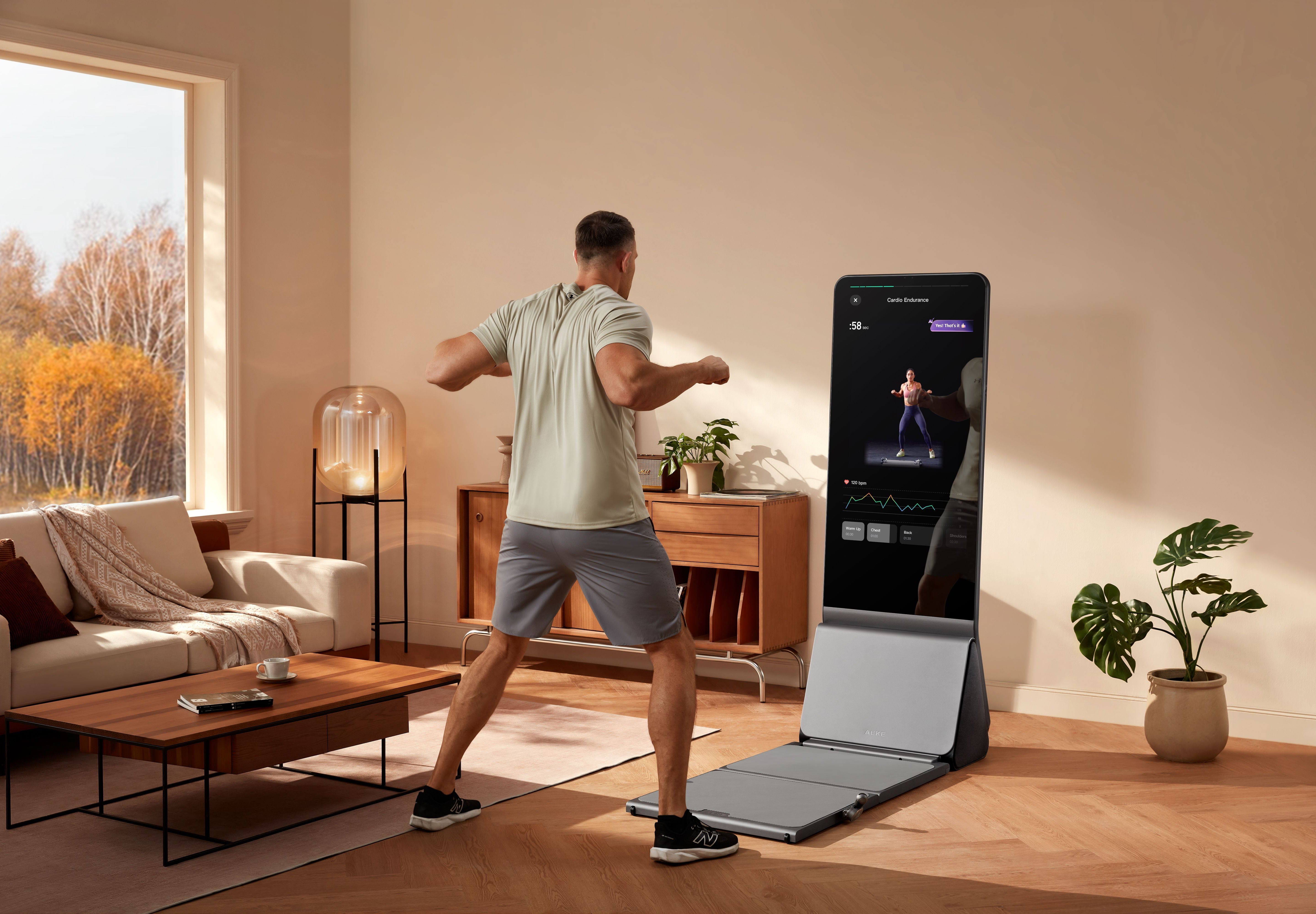 Man exercising on an AEKE smart home gym mirror in a sunny living room.