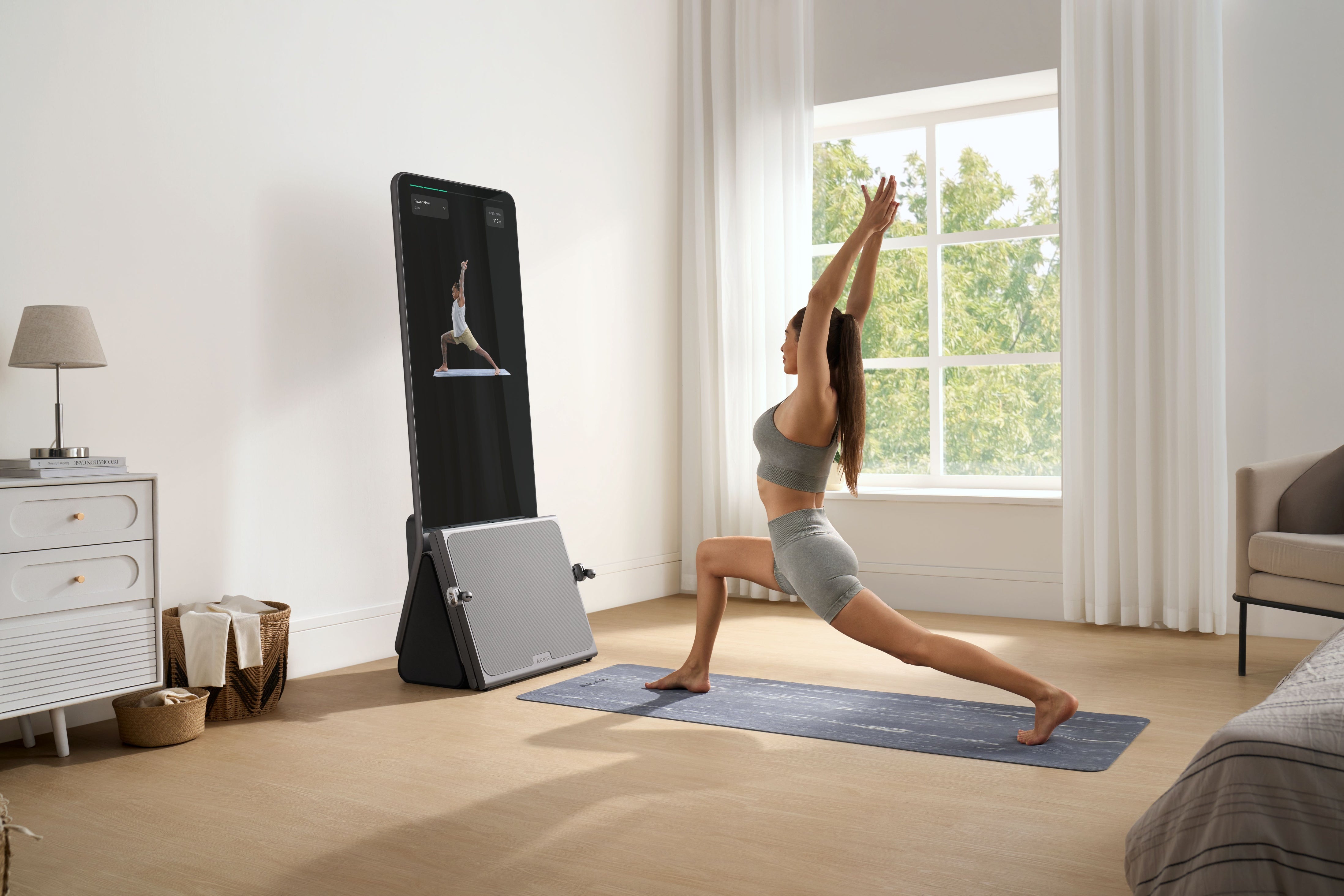 Woman doing yoga with the best all-in-one home gym in a bright bedroom