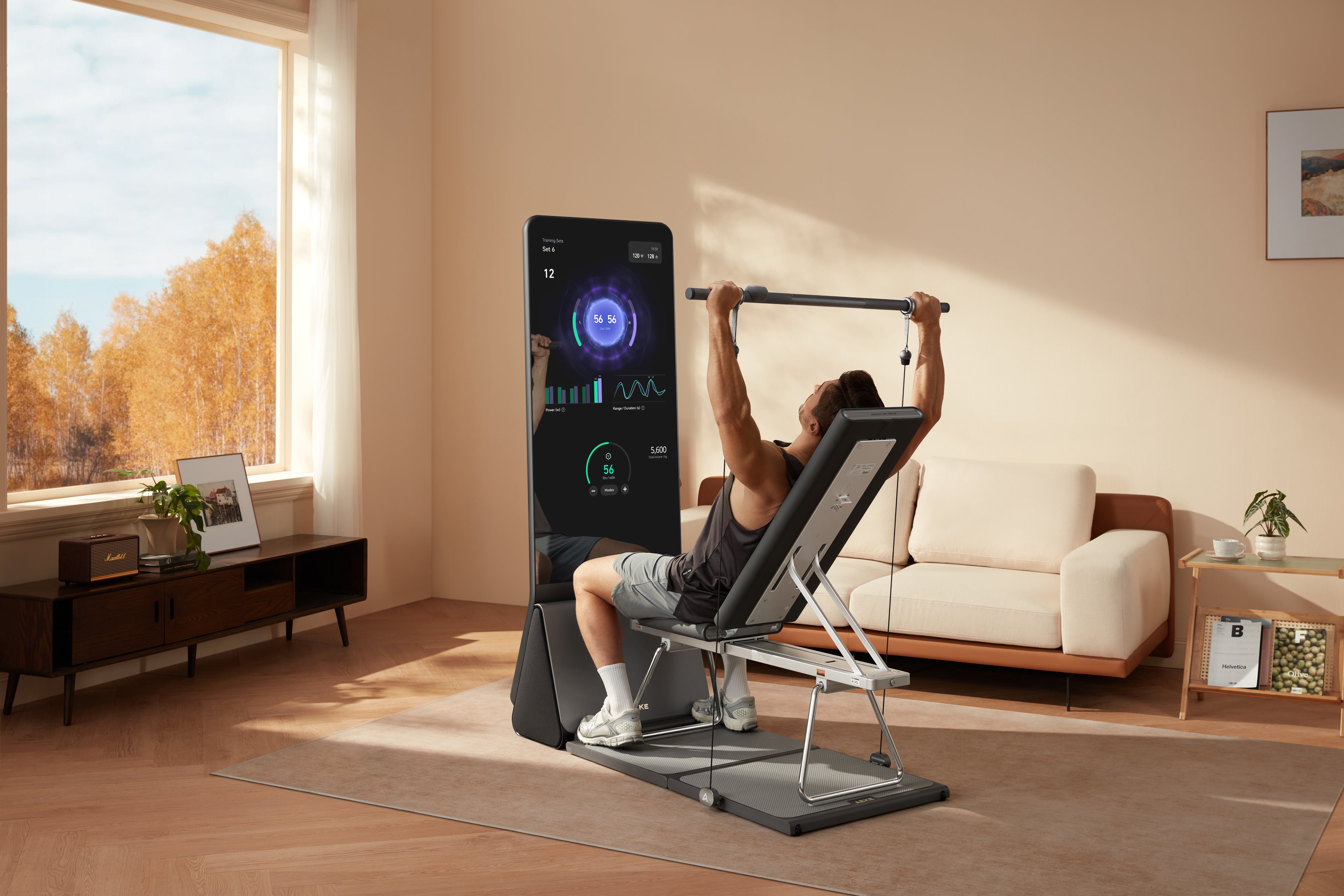 Man using a digital home strength-training machine to pull an overhead bar in a sunlit living room