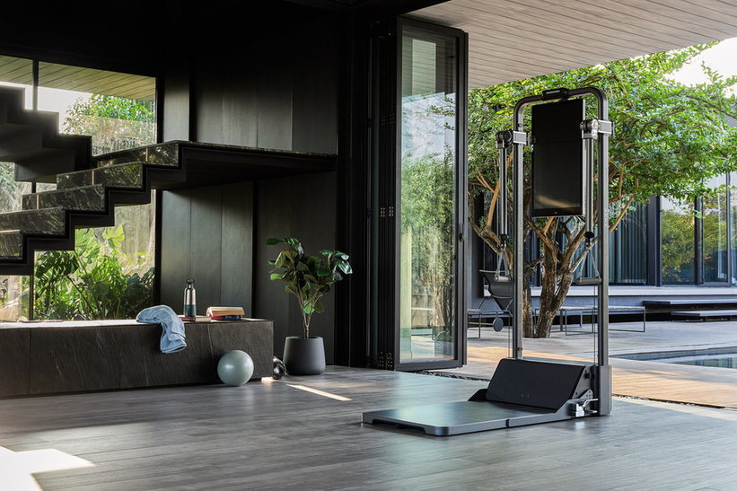 Freestanding cable resistance machine in a bright home gym, illustrating the equipment shoppers should check warranty and return terms for.