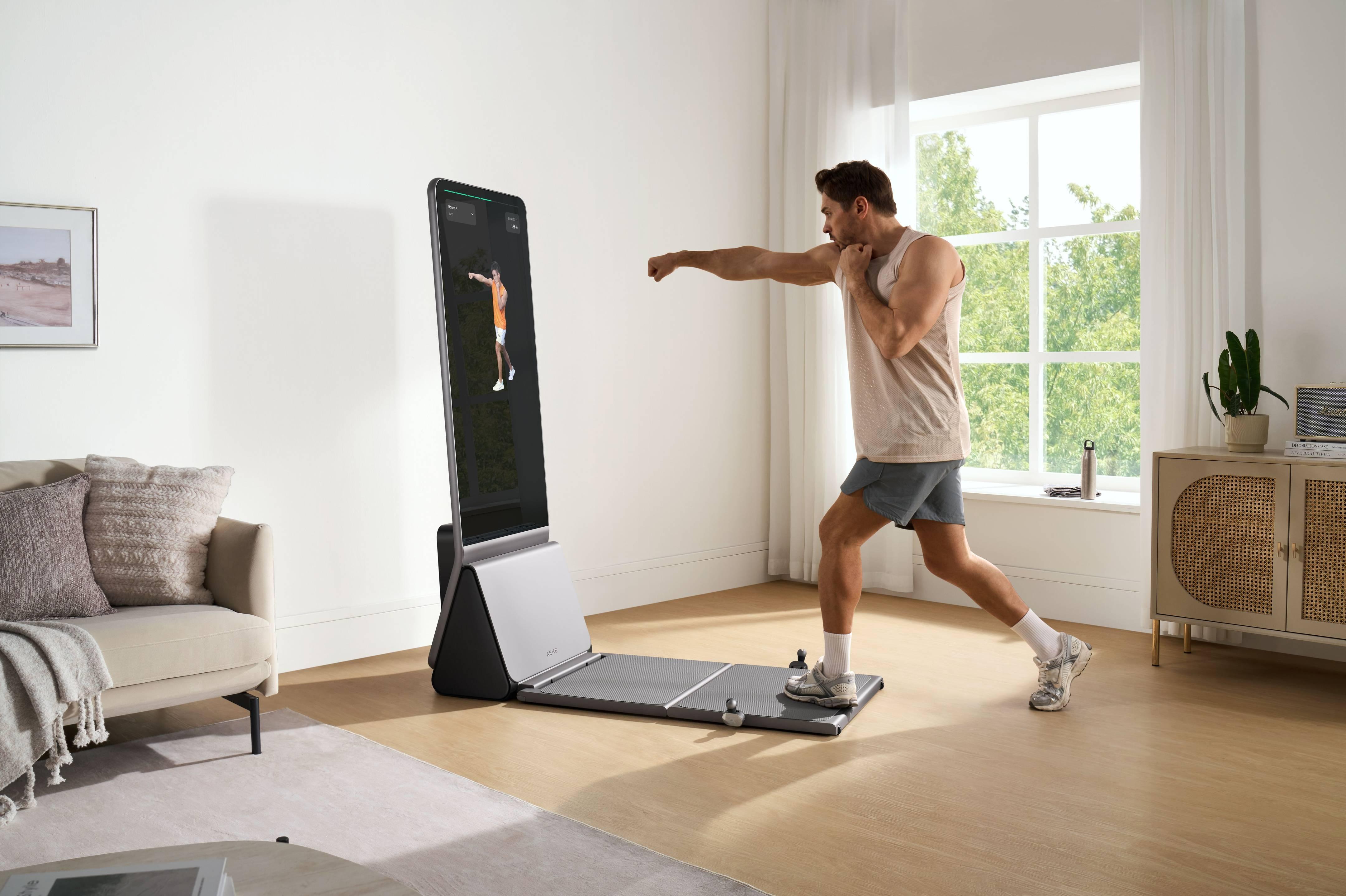 Man using AEKE smart fitness mirror for home boxing workout