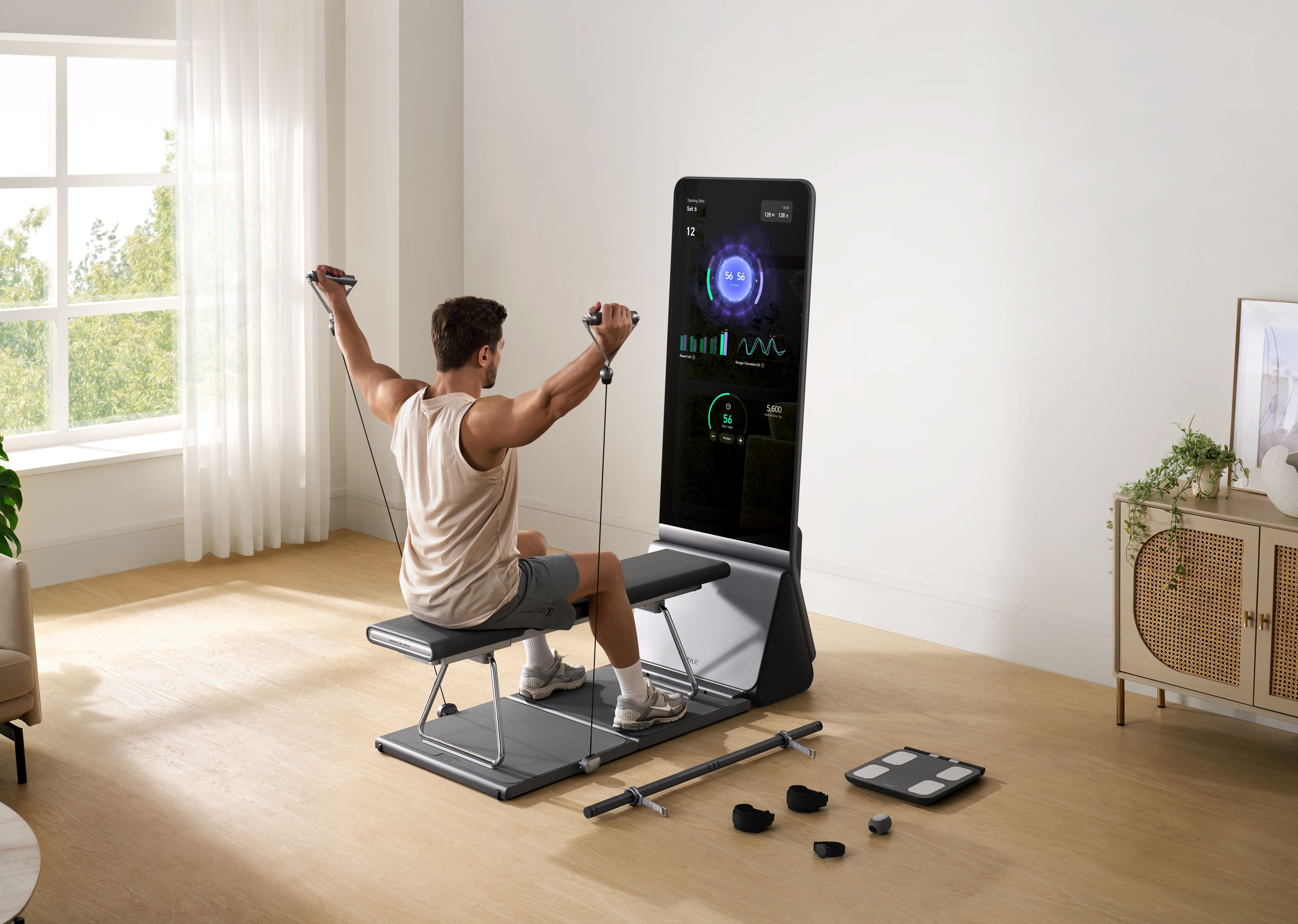 A man sits on a bench, using a smart fitness mirror and resistance bands for a full home workout.